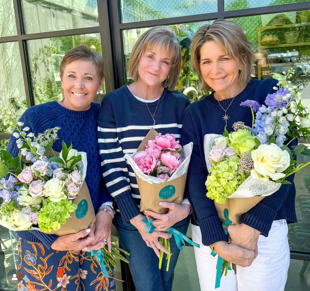 Three ladies holding florist bouquets